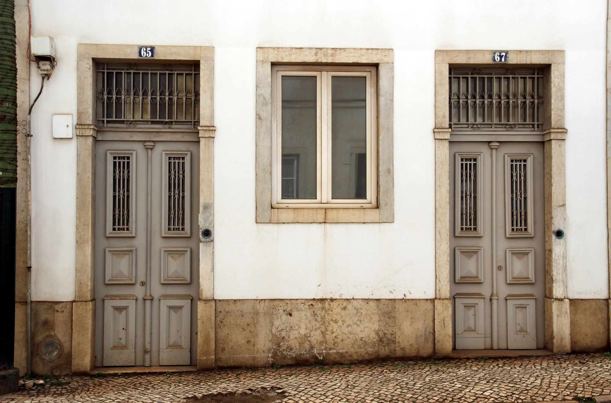 Two panelled front doors on a whitewashed Lisbon street