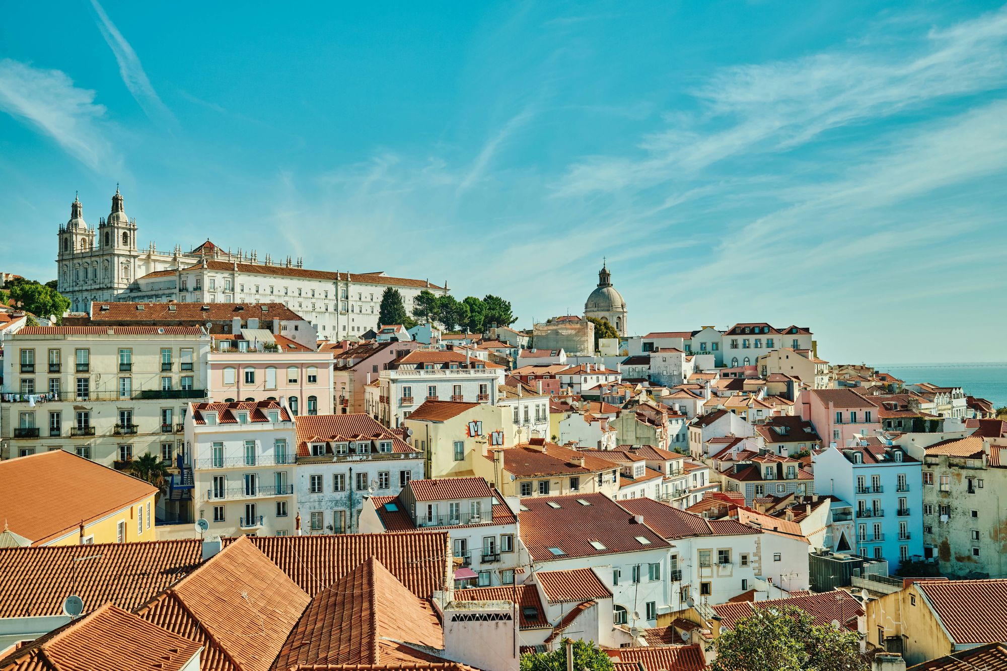 Pastel houses climbing towards São Vicente de Fora in Lisbon